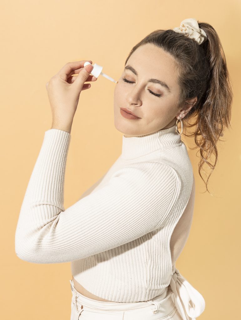 chica aplicando sérum de vitamina c